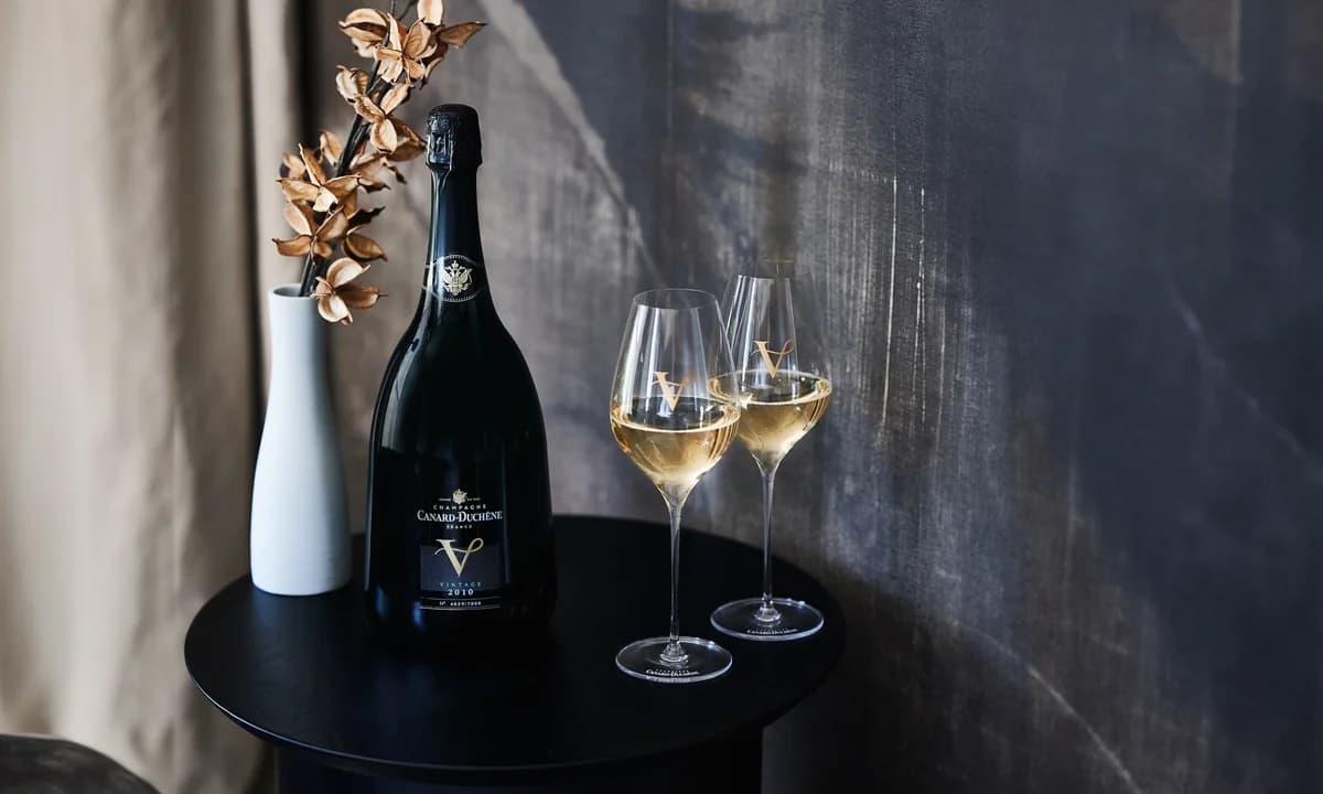 Magnum Champagner Canard-Duchêne V 2010, serviert in zwei gravierten Flöten