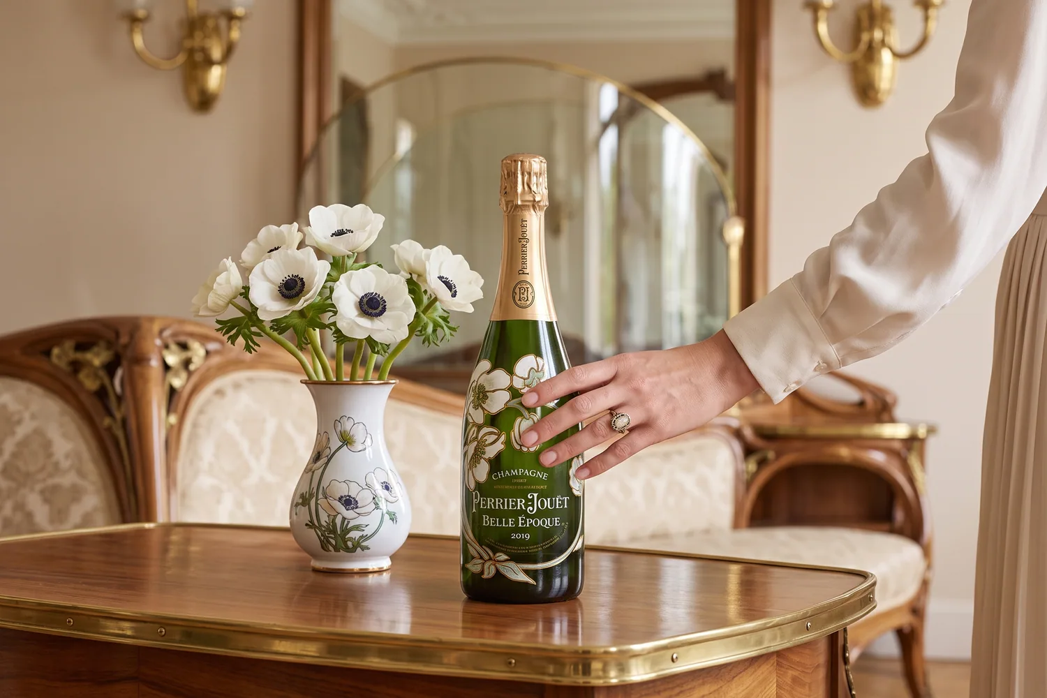Bouteille de Perrier-Jouët Belle Époque aux anémones peintes, posée près d'un vase d'anémones blanches dans un salon Art nouveau